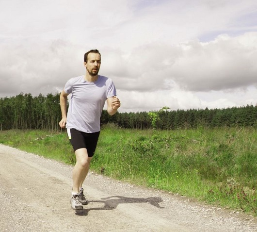 Man running along straight dirt path